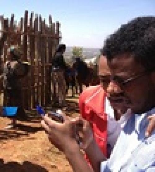 Bereket and Tesfahua collecting data in Ethiopia using mobile phone at a standpipe (by Marieke Adank)