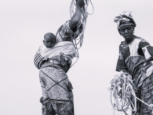 Two women fetching water with rope and bucket